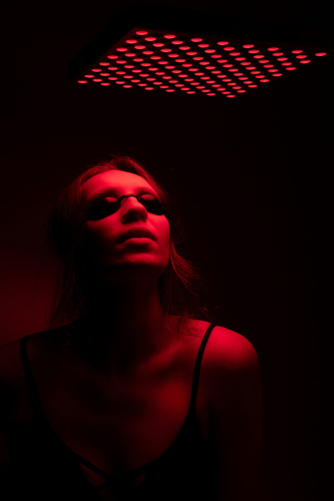 women with protective glasses on under red light, portraying red light therapy at soma house