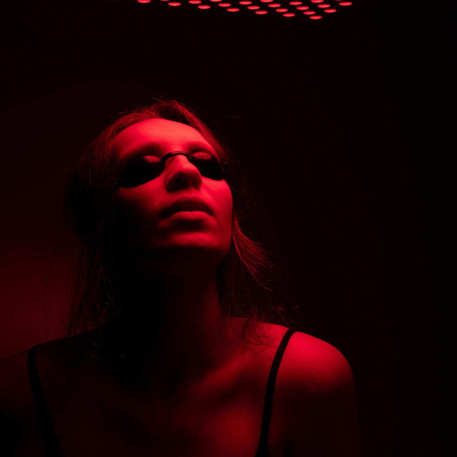 women with protective glasses on under red light, portraying red light therapy at soma house