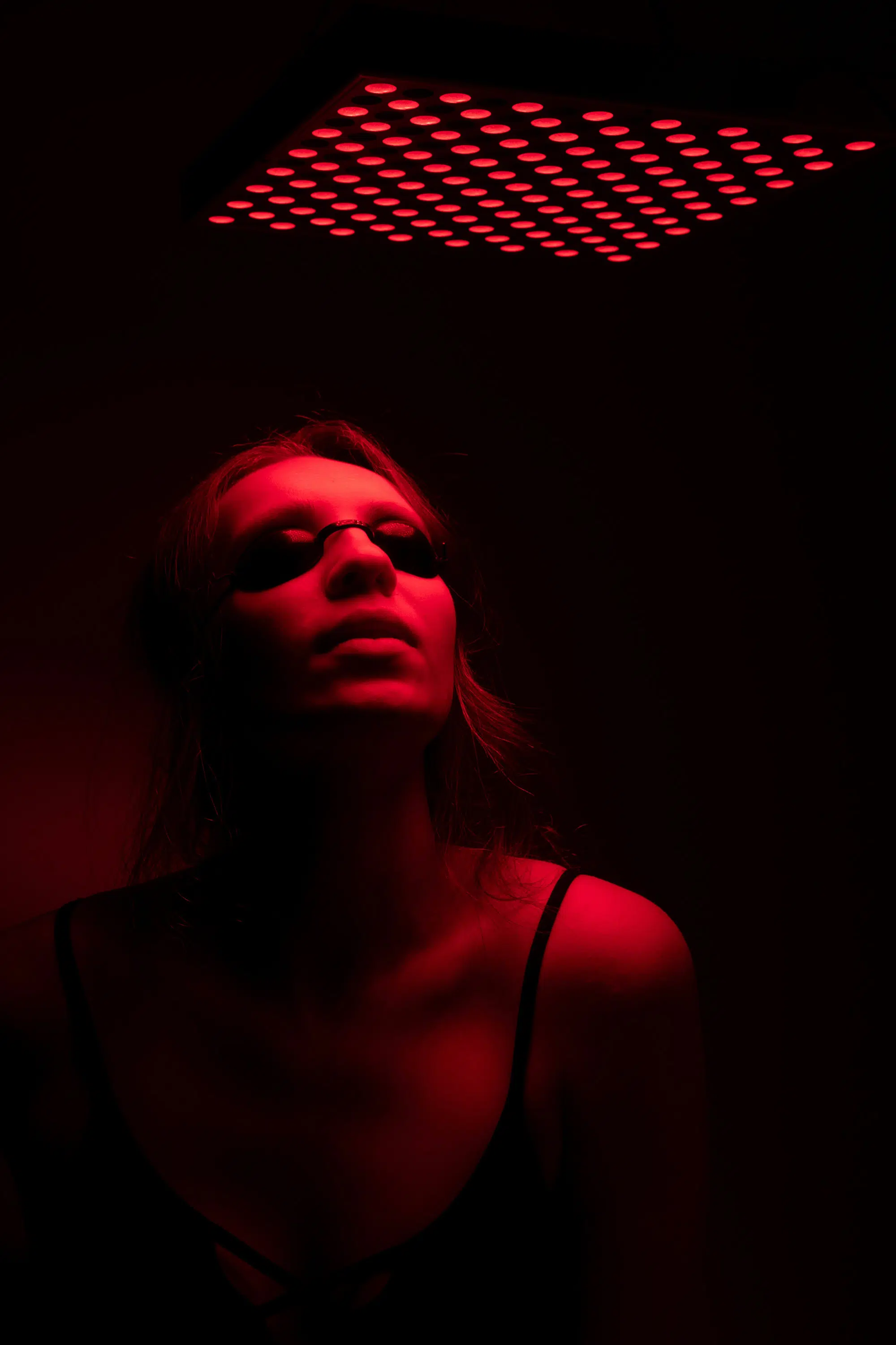 women with protective glasses on under red light, portraying red light therapy at soma house